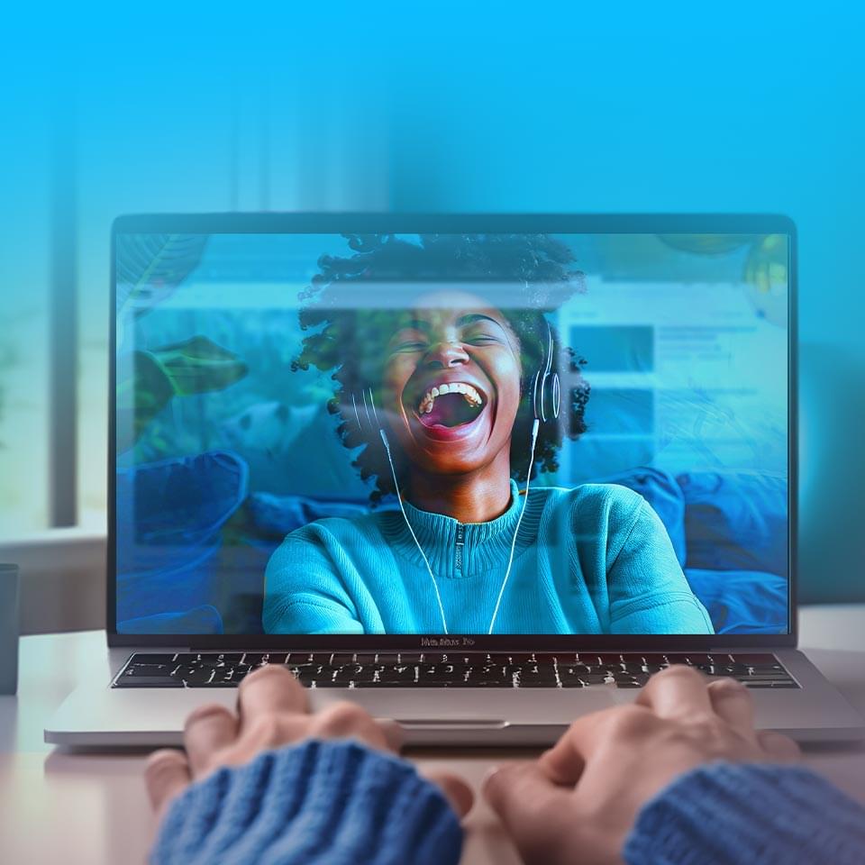 Woman laughing on laptop screen